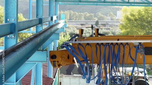 Mounting an overhead crane onto rails. The process of mounting an industrial overhead crane, lifting it, and installing it onto steel rails inside a production facility.