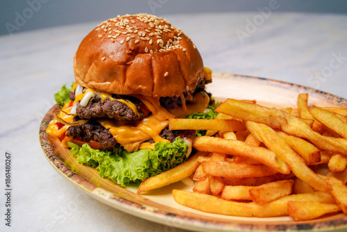 Wallpaper Mural Burger served with french fries on ceramic plate showing fast food meal, fresh ingredients, melted toppings, and crispy fries in clean restaurant style presentation. Torontodigital.ca