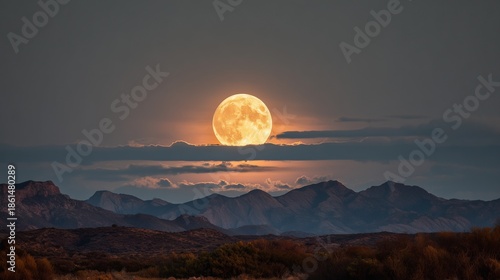 A dramatic and ethereal wide shot of a full moon in a warm, golden glow, majestically rising or setting behind a layer of soft, horizontal clouds. 