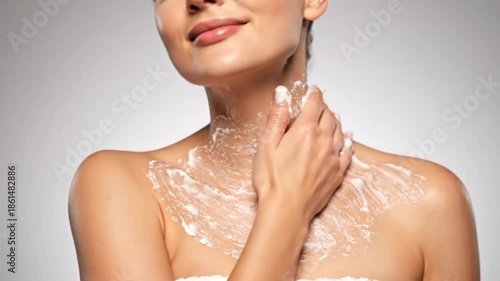 A woman applying cosmetic cream to her chest and neck, with a smile