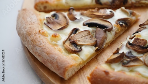 A close-up view of delicious white mushroom pizza slices arranged on a wooden board