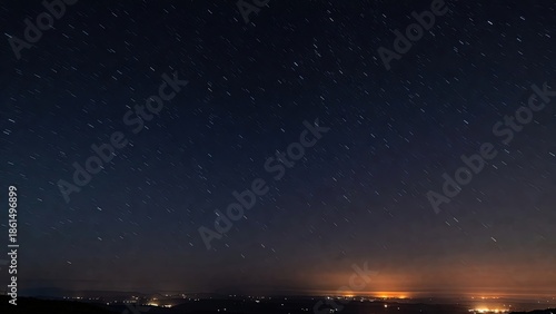 Vivid star trails arc across dark night sky above a glowing city