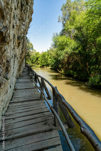 Wooden Path Along Limestone Cliff and River