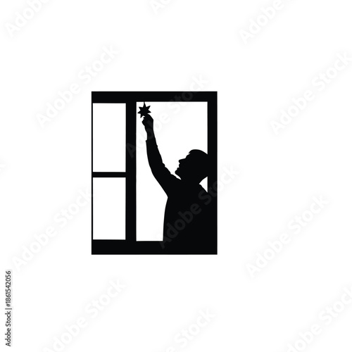 Silhouette of a person holding star up to window
