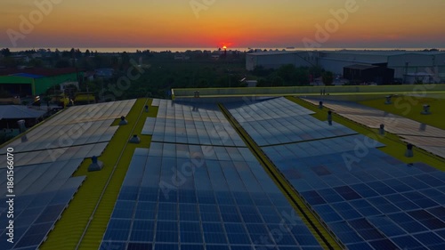 Wallpaper Mural Aerial view of a solar power plant with solar panels located beside a busy road, leading toward an urban cityscape at sunset.  Torontodigital.ca