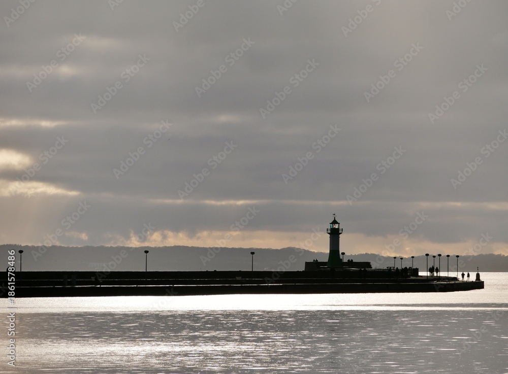 Fototapeta premium Leuchtturm im Hafen von Sassnitz auf Rügen mit Wetterwolken