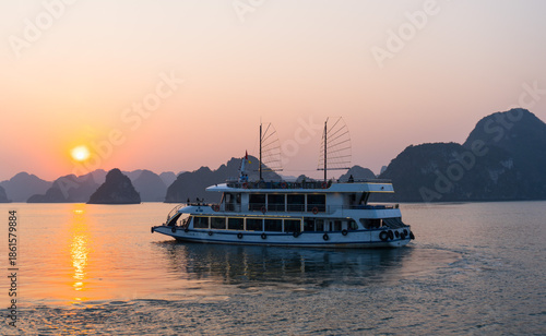 Quadro em tela A sunset and a boat at Ha Long Bay, Vietnam