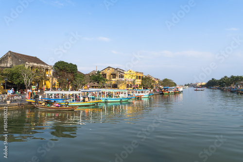 Waterfront with boats and yellow buildings in Hoi An, Vietnam