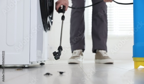 Tableau sur toile Pest control worker spraying insecticide indoors, closeup