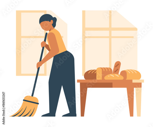 A person sweeps the floor in a room with a table full of bread.