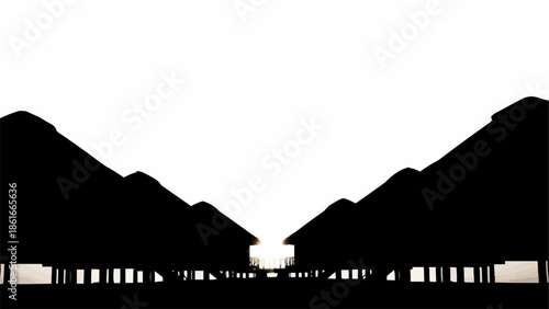 Silhouette of thatched roof huts on stilts against a white sky.