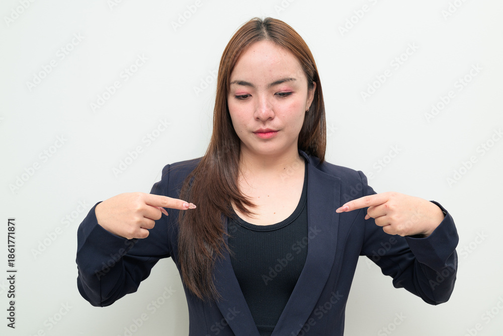 Φωτογραφία Portrait of a young Asian businesswoman against white background pointing at sel