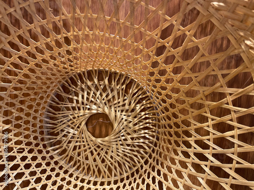 A close-up photograph of woven handcrafted objects showing circular patterns, interlaced structure, and decorative design details.