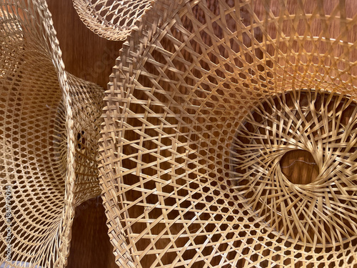 A close-up photograph of woven handcrafted objects showing circular patterns, interlaced structure, and decorative design details.