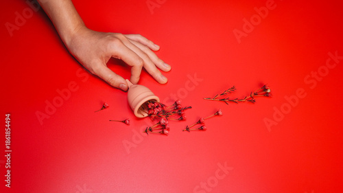 Menstrual Cup with Red Flowers on Red Background Concept Period Flow