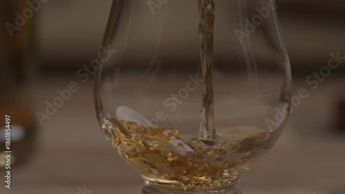 Empty glass being filled with alcohol drink