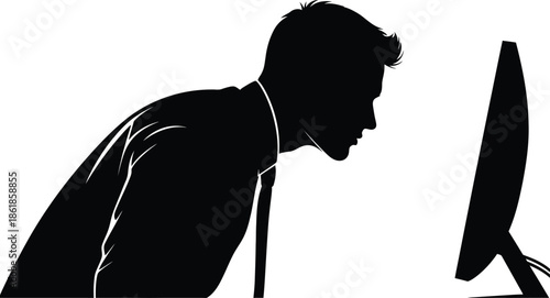 Silhouette of a businessman intensely focused while leaning forward to observe something displayed closely upon a computer monitor screen