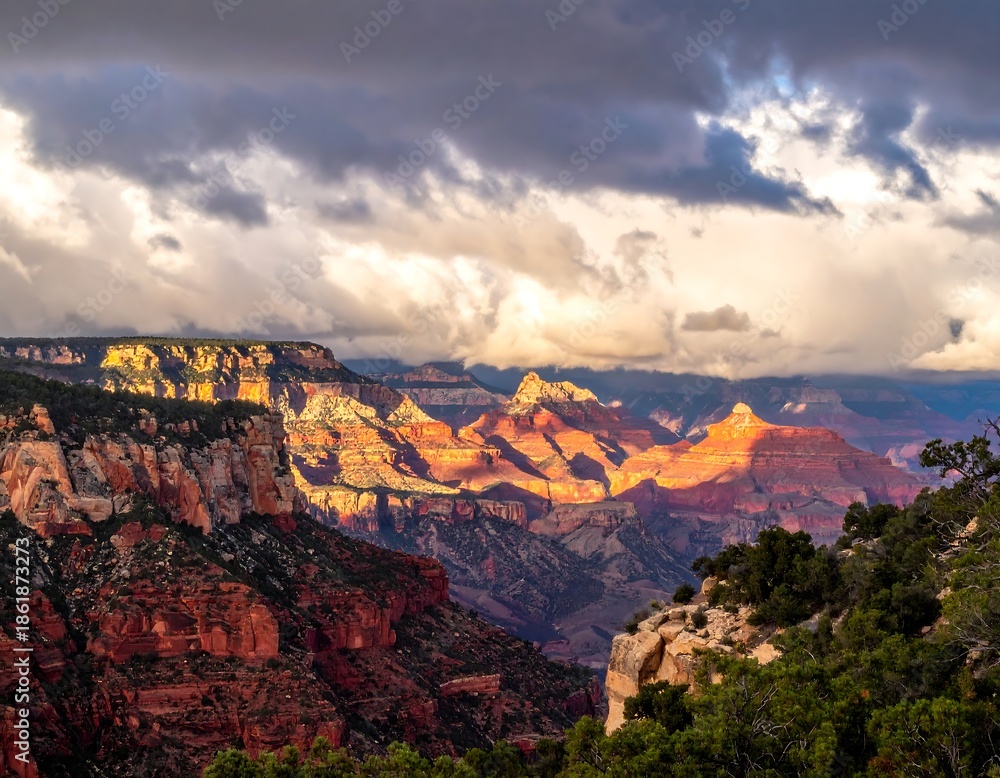 Fototapeta premium Expansive canyon landscape with sunlight breaking through dramatic clouds