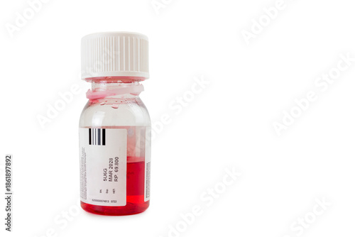 Red liquid medicine in a transparent plastic bottle with a white cap and label, showing batch number and expiration date, isolated on a white background.