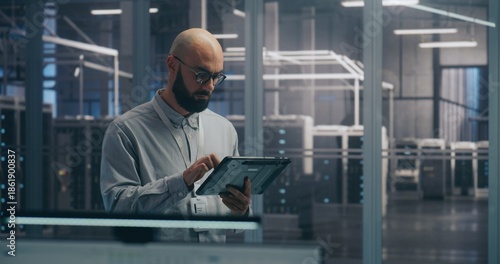On Site Coordination, IT Specialist Using Tablet to Diagnose Rack Status. Focused IT Professional Diagnoses Server Rack Status Using Mobile Tablet Device. Coordination and On Site Troubleshooting.