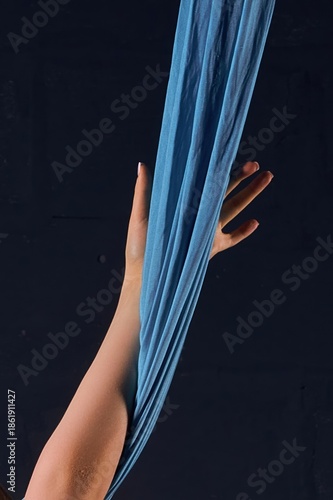 Wallpaper Mural Graceful female hand grasping blue aerial silk against a dark background Torontodigital.ca