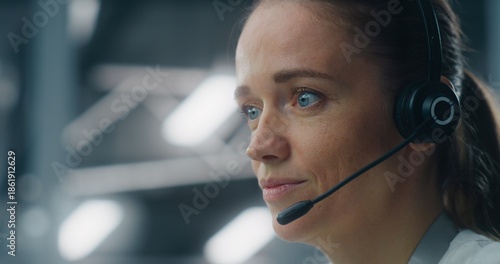 Billede på lærred Close Up of Dedicated Female Technician Responding to Real Time System Alerts, Communicating Via Headset at Console in Data Center