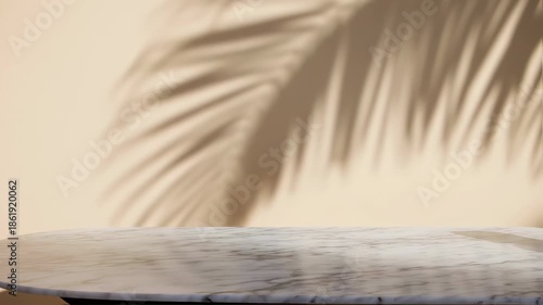 A marble surface with a blurred palm leaf shadow against a warm beige backdrop