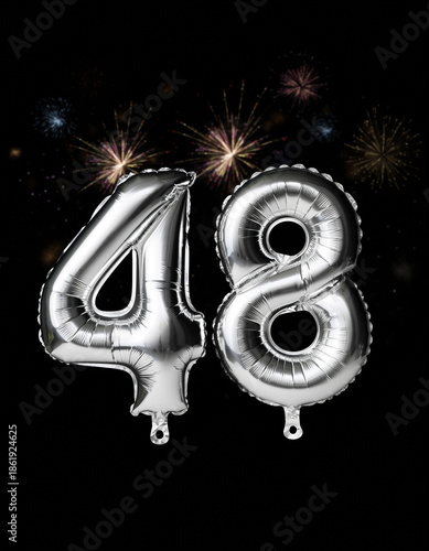 Silver balloon number 48 with fireworks in the background. Festive scene for birthday or anniversary party