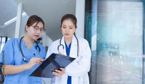 Two asian female doctor with clipboard in modern clinic, Doctor woman working with human anatomy virtual interface icons in hospital.