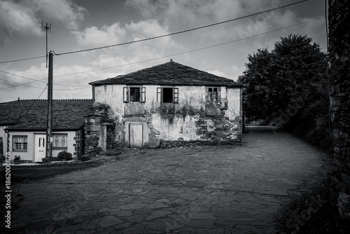 Traditional rural stone house with wooden gallery and slate roof