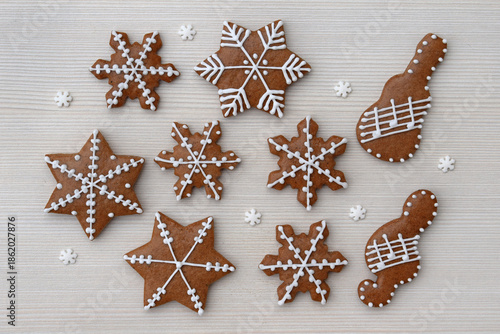 Romantic decorated gingerbread cookies in a shape of star, snowflake, guitar and treble clef with notes on a staff, small snowflakes around
