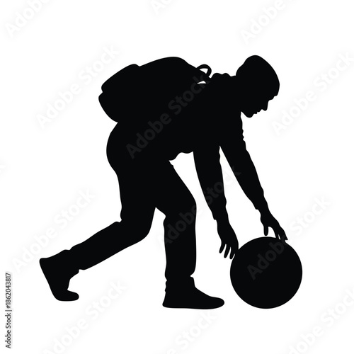 Silhouette of a person with a backpack bending to pick up a ball against a white background.