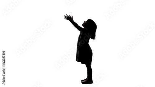 A silhouette of a young girl standing with her arms raised in a gesture of freedom and joy