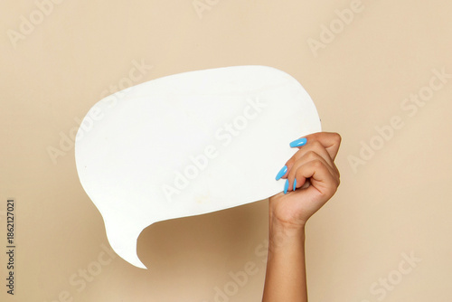 Woman's Hand with Blue Manicure Holding Blank White Speech Bubble Sign