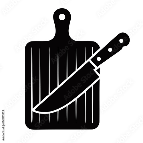 A knife lies on a chopping board, ready for kitchen preparation.