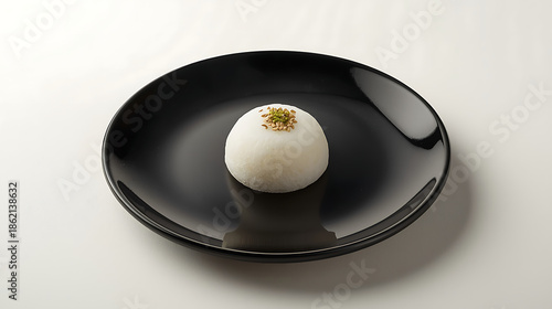 Single white dessert on black plate