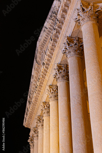 Low angle shot of illuminated Corinthian columns of Palazzo Barbieri in Verona, Italy. A powerful image of neoclassical architecture at night.