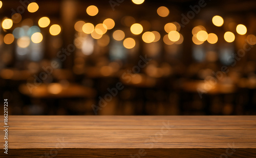 Close-up of a wooden table top in a restaurant, with blurred bokeh lights creating a warm ambiance