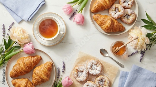 Mother's Day breakfast flat lay with tea, flowers, and pastries  