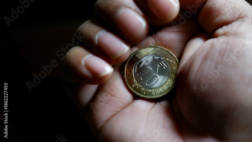 Rupee Coin in Palm Showing Financial Struggle, Inflation, Savings and Monthly EMI Payments