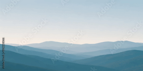 A serene mountain landscape at sunrise features mist and fog rolling through a forested valley under a blue sky filled with clouds as the morning sun casts a glow over the horizon