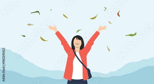 Happy young woman with her arms outstretched enjoying falling autumn leaves in a peaceful mountain landscape.