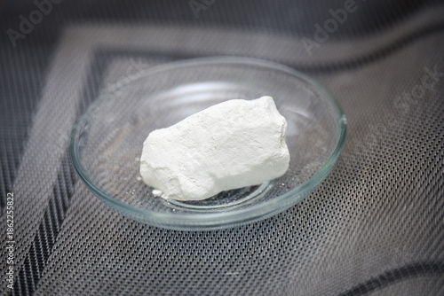 Piece of edible chalk on a glass saucer for consumption to increase calcium, reduce stomach acidity. Unusual dietary supplement