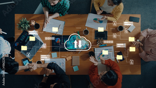 Foto Aerial view of a professional meeting with individuals discussing strategies and analyzing data around a wooden table with cloud technology visuals integrated