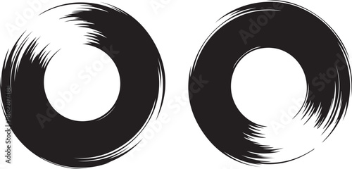 Two textured black circular paint brush strokes with a white inner circle on a plain white background