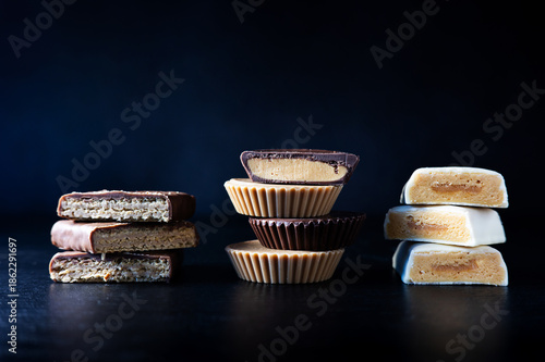 Assorted protein bars with different coatings, healthy fitness snacks on a dark background.