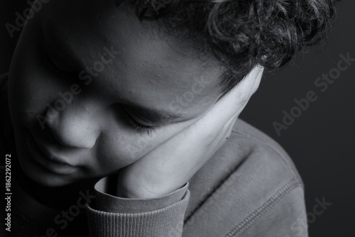 Fotografie deaf boy and suffering from deafness and hearing loss on black grey background w