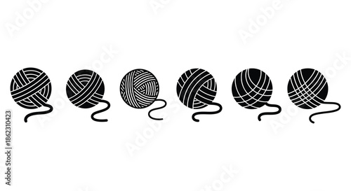 A series of black and white yarn balls with trailing ends arranged in a horizontal line