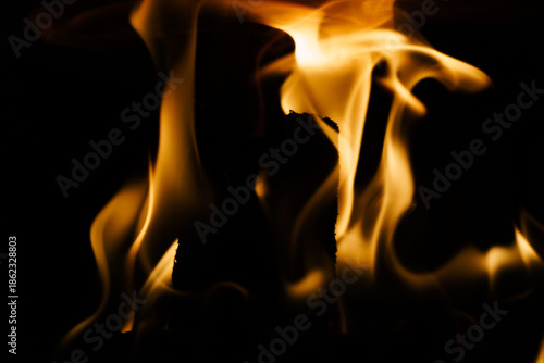 Close-up of a fire in a fireplace, against a black background