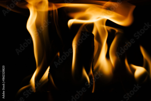 Close-up of a fire in a fireplace, against a black background